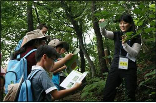 KIOM 본초탐사대에 참가한 아이들이 전문 연구원의 설명을 들으며 본초에 대한 현장학습을 하고 있다.