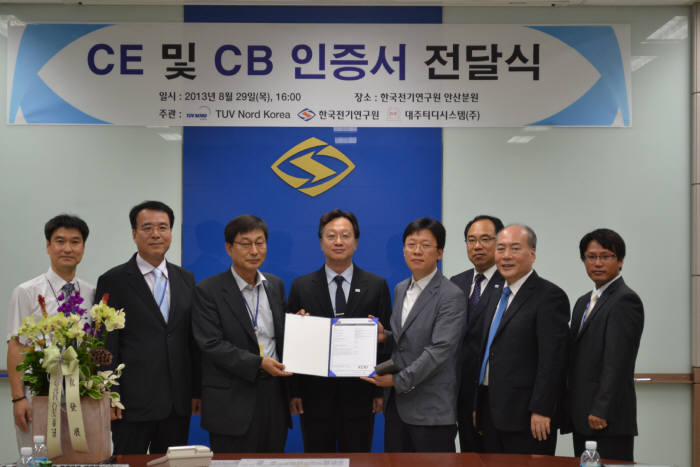 박남옥 KERI 전기기기평가본부장(왼쪽 세 번째)과 이정창 티유브이노르트코리아 대표(〃 네 번째)가 대주티디시스템 관계자에게 CE· CB 인증서를 전달하고 있다.