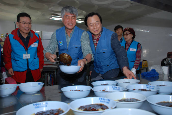 이주연 포스코ICT 전무(우측부터)와 최승준 정선군수, 올림픽 금메달리스트인 김원기씨가 장애우에게 줄 자장면을 덜고 있다.