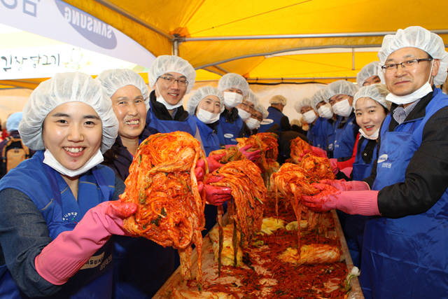 삼성테크윈은 12일 성남시 야탑역 광장에서 임직원과 지역주민 등 1200여명이 참여해 `사랑의 김장담그기` 자원봉사활동을 펼쳤다. 이날 담근 김치는 성남시 저소득층 3400가구에 전달될 예정이다. 임직원과 시민들이 만든 김치를 들어보이고 있다.