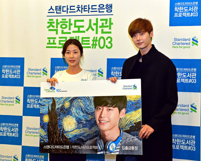 스탠다드차타드(SC)은행은 12일 서울 중구 제일지점에서 `착한 갤러리`를 개막했다. 이 날 개막식에서 직원 홍보대사 황지선씨가 `착한 도서관 프로젝트 시즌3` 홍보대사 배우 이종석씨(오른쪽)에게 `착한 통장`을 증정했다.