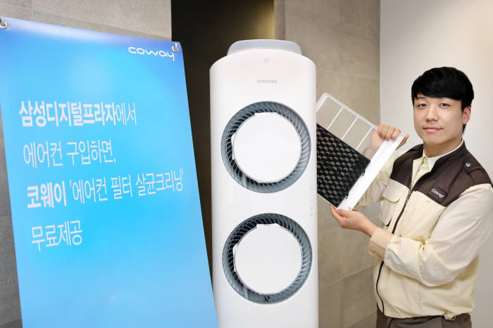 코웨이 홈케어닥터가 `에어컨 필터 살균 크리닝`을 진행하고 있다.