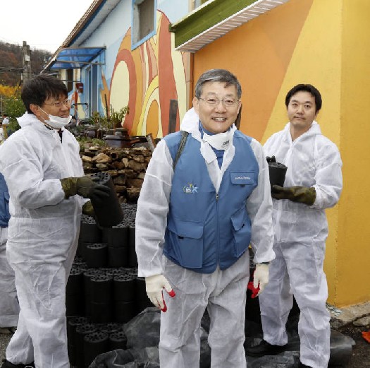 윤동준 포스코에너지 사장(가운데)을 비롯한 임직원들이 19일 인천 서구 절골부락 주민들에게 연탄을 배달하고 있다.