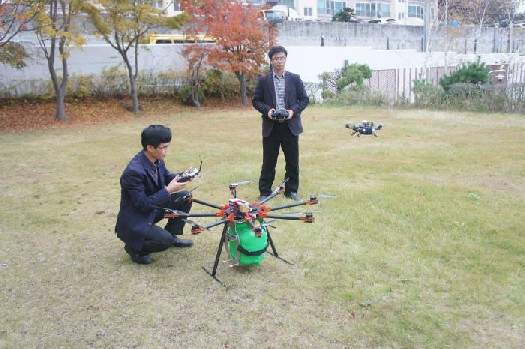 마린로보틱스 관계자들이 GPS를 활용해 비행하는 농약살포 방제용 드론을 직접 작동해보이고 있다.