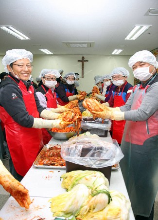 KT DS 직원이 `사람 김치 나누기` 행사에 참여해 김장을 담그고 있다.