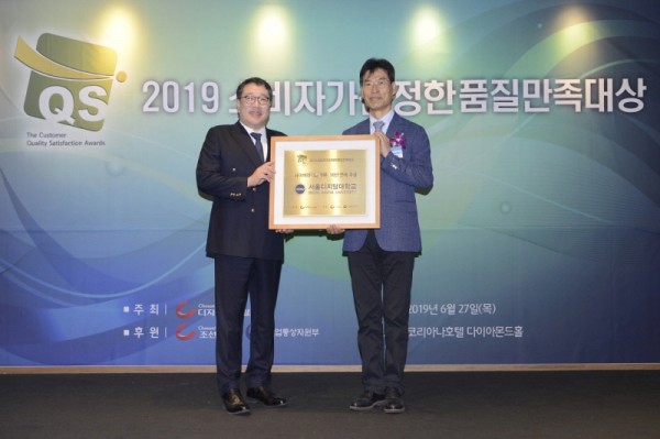 서울디지털대학교 홍필기 입학처장(우)이 ‘소비자가 선정한 품질만족대상’에서 10년 연속 사이버대학 부문 대상을 최초 수상 후 기념동판을 받고 있다. 사진=서울디지털대학교. 