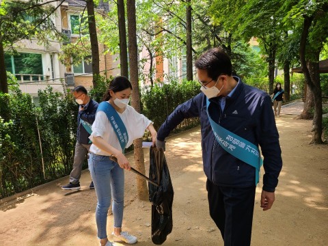 LX 한국국토정보공사 서울지역본부 임직원이 '공원 녹지 돌보미' 일환으로 학동근린공원에서 쓰레기를 줍고 있다.