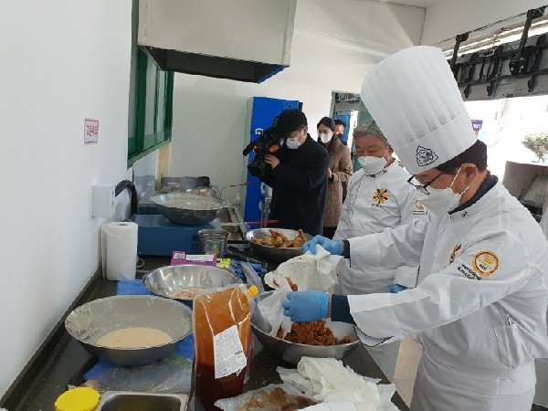 추창민 식품연구소장이 오리 후라이드를 양념소스에 버무리는 모습. 제이에스물산 제공.