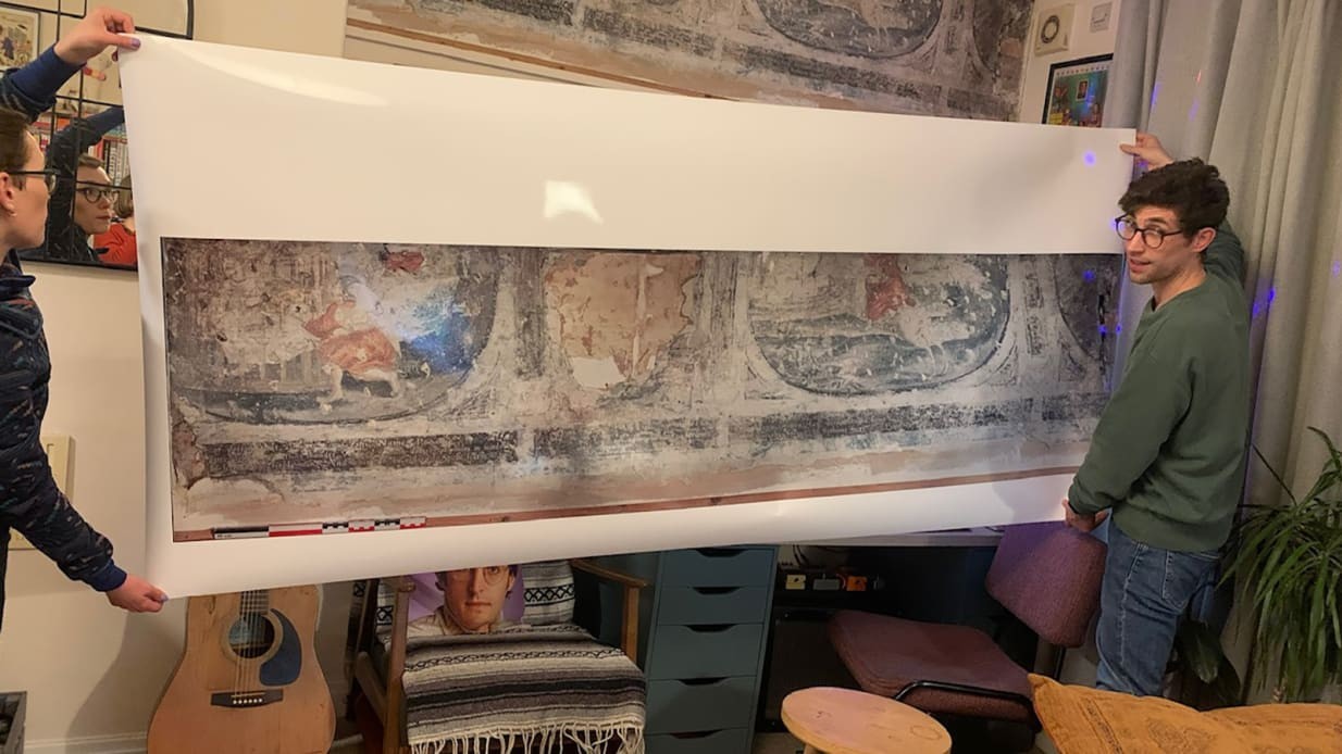 잉글랜드 요크시의 한 아파트 벽 뒤에서 발견된 400년 된 벽화. 뒤가 실물이며, 앞에 루크 버드워스 씨가 든 사진은 벽화를 스캔한 것이다. 사진=루크 버드워스