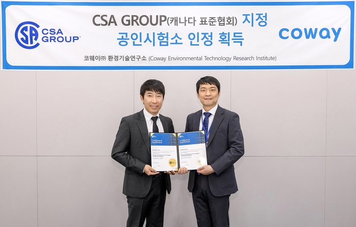 지경철 코웨이 환경기술연구소 TQA실장(왼쪽)과 양대석 CSA그룹 한국 지사장이 ‘CSA그룹 지정 시험소’ 인증서를 들어 보이고 있다.