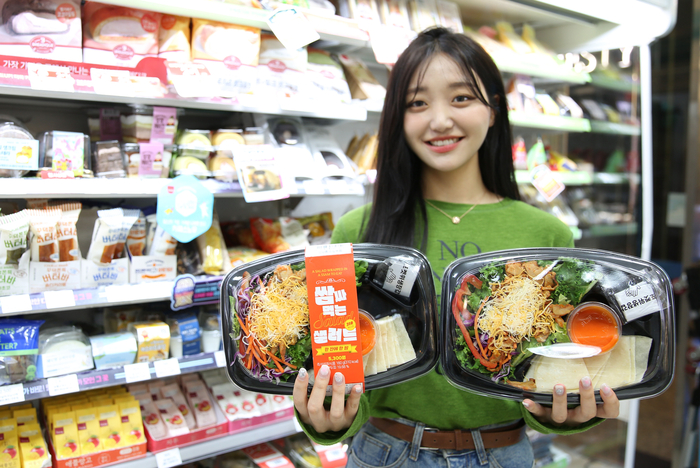 모델이 GS25가 첫 안주형 샐러드 출시한 ‘쌈싸먹는 치킨 샐러드’를 들고 포즈를 취하고 있다.