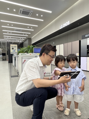 LG전자 베스트샵 달서본점 직원이 아이들에게 안전가 전자제품 사용법을 알려주고 있다.