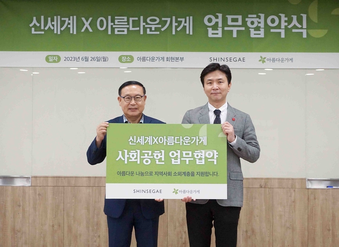 이원호(오른쪽) 신세계 CSR담당 상무와 장윤경 아름다운가게 상임이사가 업무 협약을 맺고 기념촬영을 하고 있다.