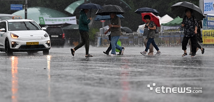 지난해 7월 장맛비에 서울 여의도 국회 앞에서 시민들 발걸음을 재촉하고 있다. 이동근 기자 foto@etnews.com