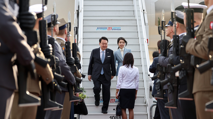 북대서양조약기구(NATO·나토) 정상회의 참석을 마치고 폴란드 공식 방문 일정에 들어가는 윤석열 대통령과 김건희 여사가 12일 오후(현지시간) 바르샤바 쇼팽 국제공항에 도착, 전용기인 공군 1호기에서 내린 뒤 영접객과 인사하고 있다. 연합뉴스