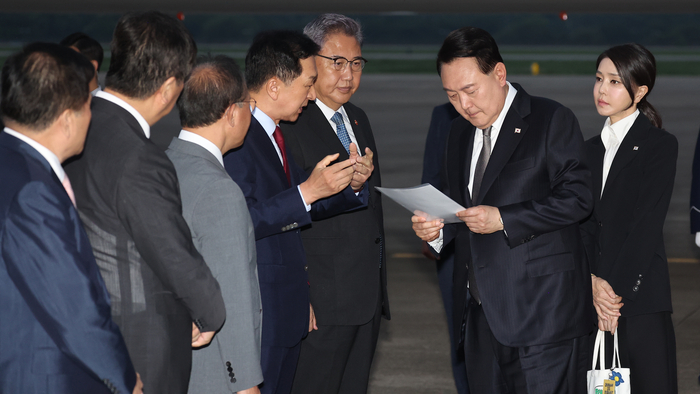 리투아니아에서 열린 북대서양조약기구(NATO·나토) 정상회의 참석과 폴란드·우크라이나 방문을 마친 윤석열 대통령이 17일 성남 서울공항을 통해 귀국, 국민의힘 김기현 대표가 준비한 수해 관련 자료를 살펴보며 대화하고 있다. 연합뉴스