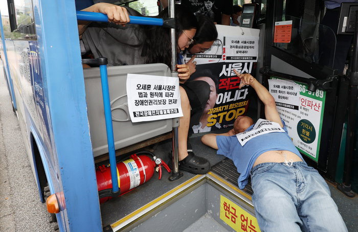 17일 혜화동로터리 버스정류장에서 전국장애인차별철폐연대 활동가가 '서울시의 전장연 탄압 중단'을 촉구하며 버스 탑승 시위를 벌이고 있다. 연합뉴스