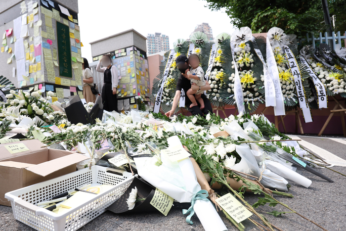 20일 오후 신규교사가 극단적 선택을 한 서울 서초구 서이초등학교 앞에서 열린 추모행사에서 추모객들이 헌화하고 있다. [연합뉴스]