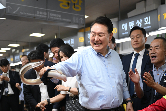 윤석열 대통령이 27일 부산 중구 자갈치시장에서 장어를 직접 손으로 잡아 보고 있다. 연합뉴스