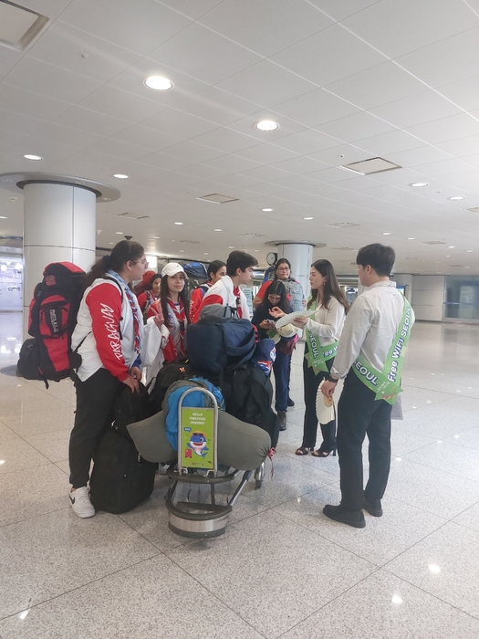 인천국제공항 관광안내소에서 외국인 입국 단체 관광객을 대상으로 서울 무료 와이파이 이용방법을 설명하는 모습