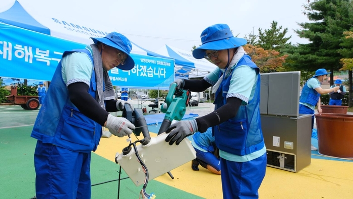 삼성전자서비스 직원이 14일 고성군 거진청소년문화의집에 설치한 이동식 서비스센터에서 침수된 가전제품을 세척, 수리하고 있다.