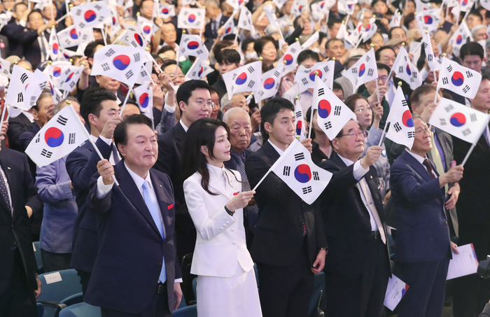 윤석열 대통령과 김건희 여사가 15일 서울 서대문구 이화여대 대강당에서 열린 제78주년 광복절 경축식에서 만세삼창을 한 뒤 태극기를 흔들고 있다. 연합뉴스