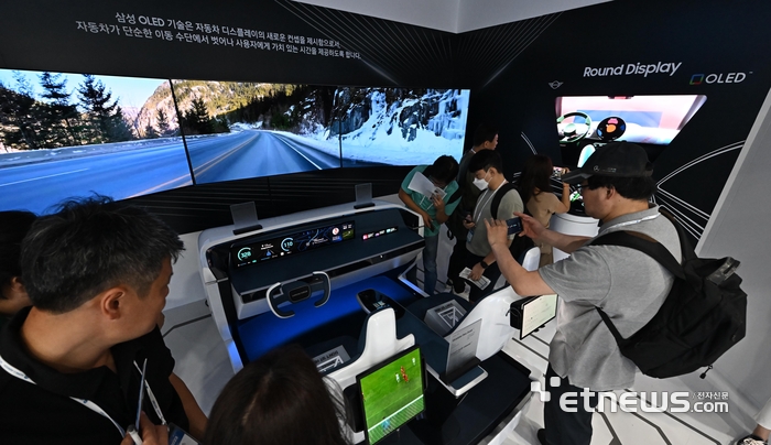 국내 양대 패널기업과 국내외 소부장 기업들이 OLED(유기발광다이오드) 관련 다양한 신기술·신제품을 한 눈에 살펴볼 수 있는 한국디스플레이산업전시회가 16일 서울 강남구 코엑스에서 열렸다. 참관객이 삼성디스플레이의 OLED 자동차 디스플레이를 살펴보고 있다. 이동근기자 foto@etnews.com