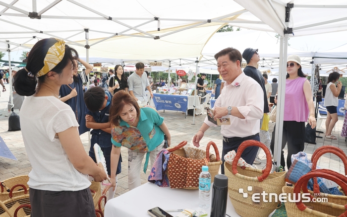 박승원 광명시장이 최근 광명동굴 빛의 광장에서 열린 '광명 빛나는 마켓'에 참여해 에코백 등을 살펴보고 있다.