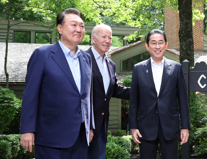 윤석열 대통령과 조 바이든 미국 대통령, 기시다 후미오 일본 총리가 18일(현지시간) 워싱턴DC 인근 미국 대통령 별장인 캠프 데이비드에서 열린 한미일 정상회의를 앞두고 로렐 로지 앞에서 기념 촬영을 하고 있다. 연합뉴스