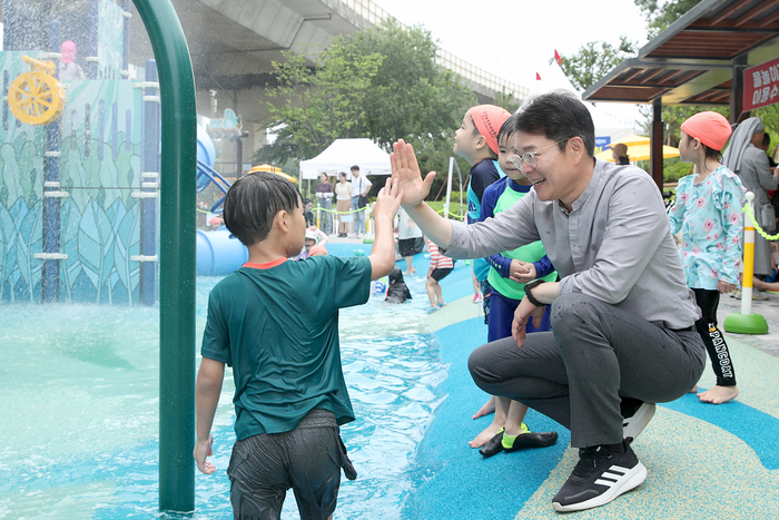 정원오(오른쪽) 서울 성동구청장이 성동구가 운영하는 물놀이장을 찾은 아이와 인사하고 있다. 사진=성동구