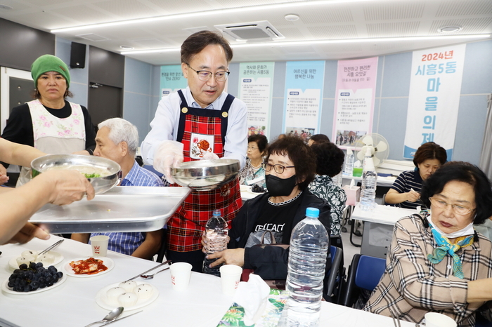 유성훈(앞줄 오른쪽 세 번째) 서울 금천구청장이 지난 20일 시흥5동 통장협의회와 함께 지역 어르신들에게 삼계죽을 대접하고 있다. 사진=금천구