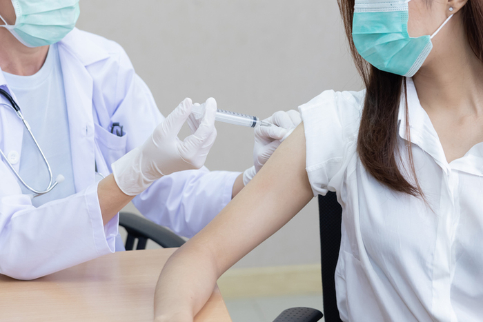 Professional Doctor Holding Syringe Injecting the Vaccine into Patient Shoulder