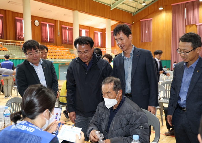 전남 고흥군 흥양농협에서 진행된 NH농협생명 2023년 제5차 농촌의료지원사업에서 김석찬 농협생명 부사장(오른쪽 두번째), 조성문 흥양농협 조합장(왼쪽 두번째)이 검진받는 조합원을 살피고 있다.