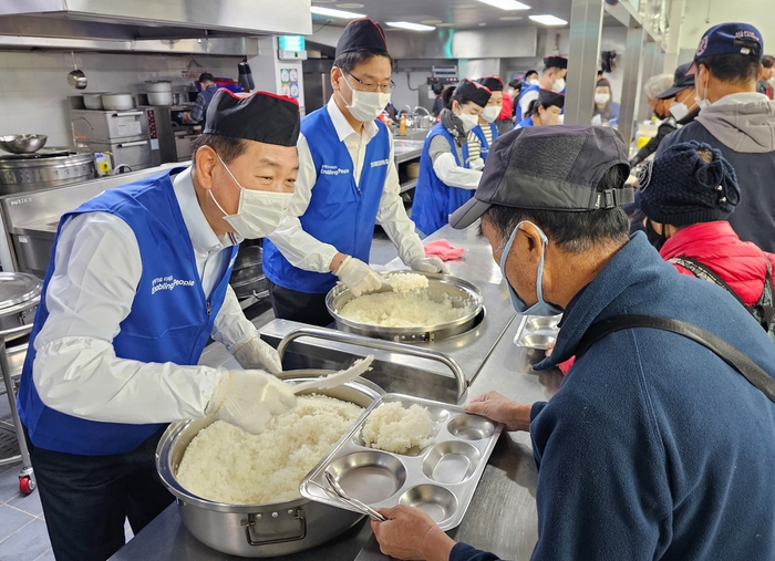 한종희 삼성전자 부회장(왼쪽)이 경기 성남시 사회복지기관 '안나의 집'에서 노숙자 대상 배식 봉사를 하고 있다.