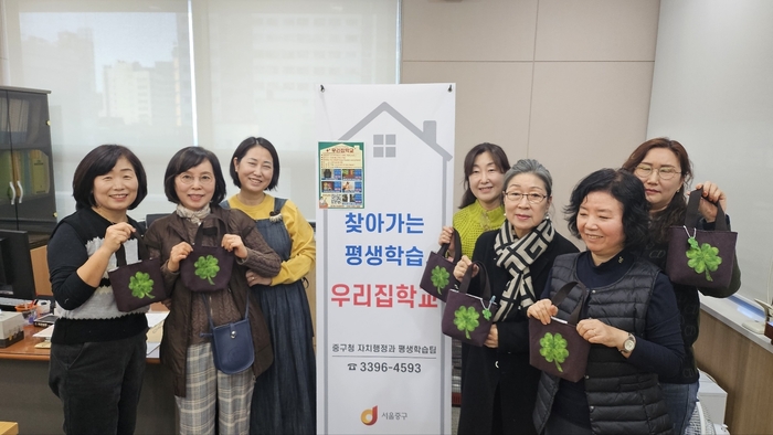 서울 중구 '찾아가는 평생학습, 우리 집 학교'의 미니토트백 만들기 수강생들이 완성품과 함께 기념사진을 찍고 있다. 사진=중구