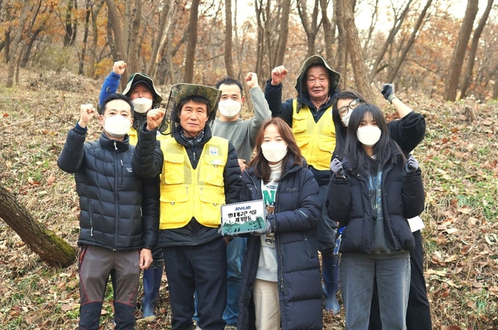 안랩 임직원들이 성남시 환경정책과 생태계교란 생물 제거반원들과 서양등골나물 제거 작업 후 기념촬영을 하고 있다.