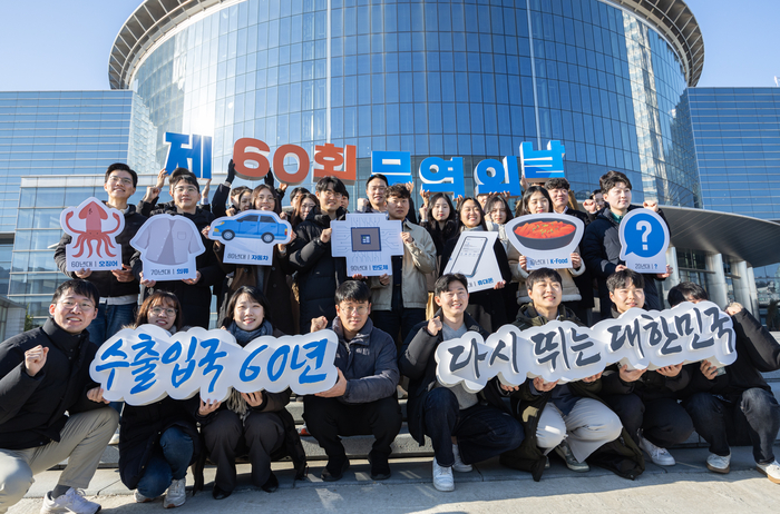 한국무역협회 임직원이 4일 '무역의 날' 기념식 60주년을 맞아 서울 강남구 코엑스 광장에서 시대별 주요 수출품(1960년대 오징어, 1970년대 의류, 1980년대 자동차, 1990년대 반도체, 2000년대 휴대폰, 2010년대 K-푸드)을 들고 았다.