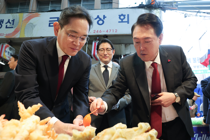 윤석열 대통령과 이재용 삼성전자 회장이 지난해 12월 6일 부산 중구 깡통시장에서 떡볶이, 만두 등 분식을 시식하고 있다. (사진=대통령실)