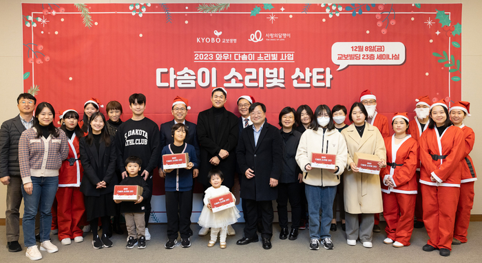 지난 8일 서울 종로구 교보생명빌딩에서 열린 '다솜이 소리빛 산타' 행사에서 교보생명 및 사랑의달팽이 관계자, 자원봉사자, 수혜아동 가족이 기념촬영을 하고 있다.