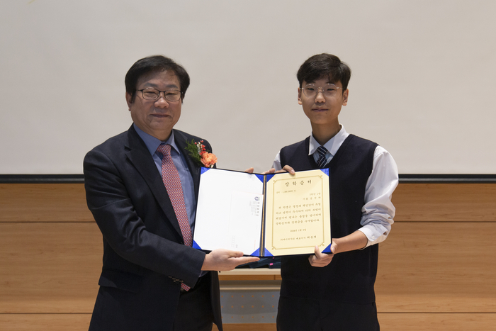 허봉재 에이치시티 대표(왼쪽)가 마장중학교 졸업생에게 장학금을 전달하고 있다.