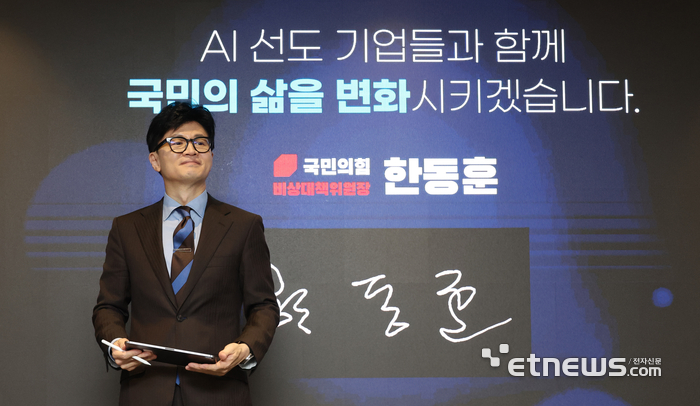 스크린에 서명하는 한동훈 비대위원장