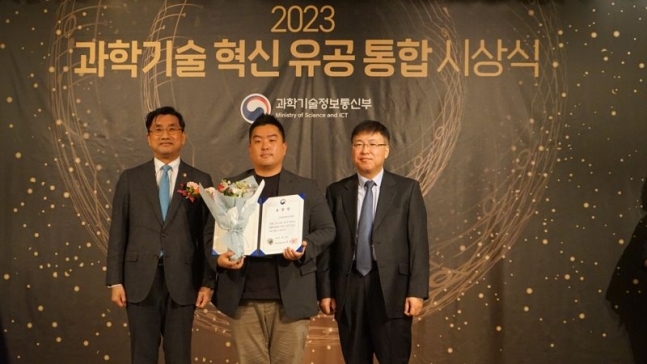 22일 서울 종로구 포시즌스호텔에서 열린 '2023 과학기술 혁신 유공 통합시상식'에서 윤인호 아이나비시스템즈 총무 팀장(가운데)과 주영창 과기부 과학기술혁신본부장(왼쪽)이 기념촬영을 하고 있다.