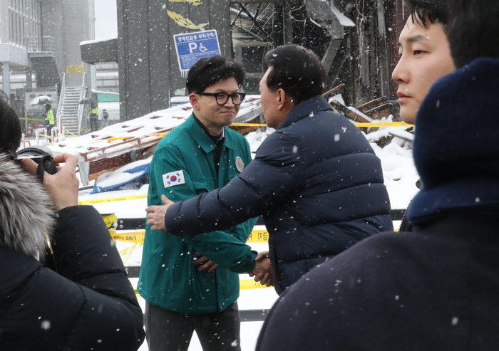 윤석열 대통령이 23일 충남 서천군 서천읍 서천특화시장 화재 현장에서 국민의힘 한동훈 비상대책위원장과 만나 포옹하고 있다.