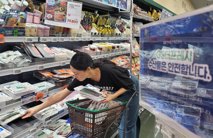 GS더프레시에서 고객이 수산물을 고르고있다.