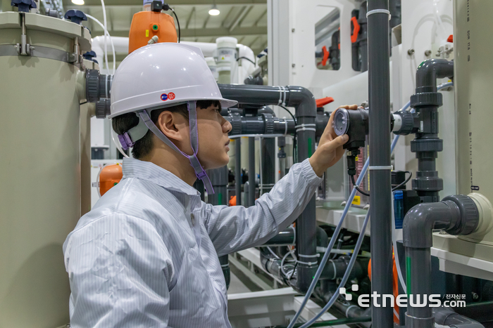 에스이에이 품질관리팀 담당자가 태양광 박막 표면처리용 장비를 점검하고 있다.