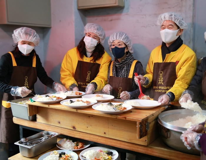 아성다이소 임직원이 지난 31일 저소득 노인과 노숙인들을 대상으로 제공하는 무료점심을 배식하고 있다.