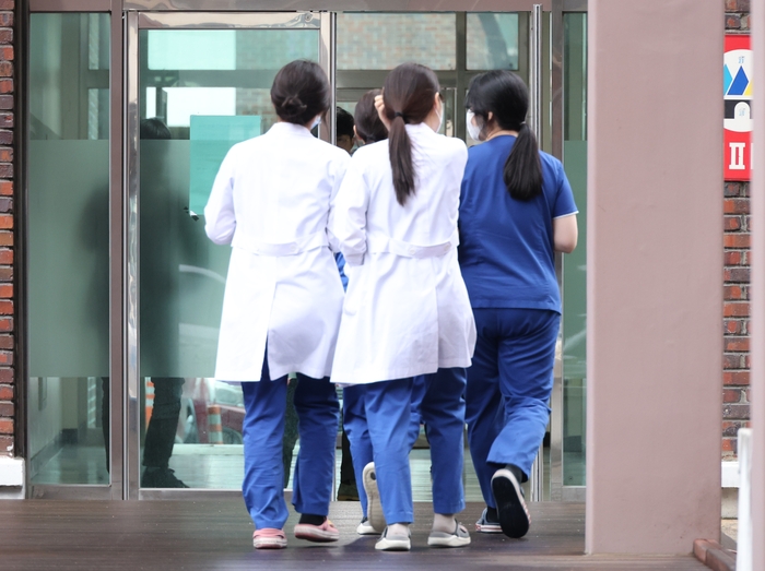 전국적으로 의대에서 동맹 휴학을 예고한 지난 20일 오후 대전 중구 충남대학교 의과대학 교정에서 의료진들이 걸어가고 있다.[연합뉴스]