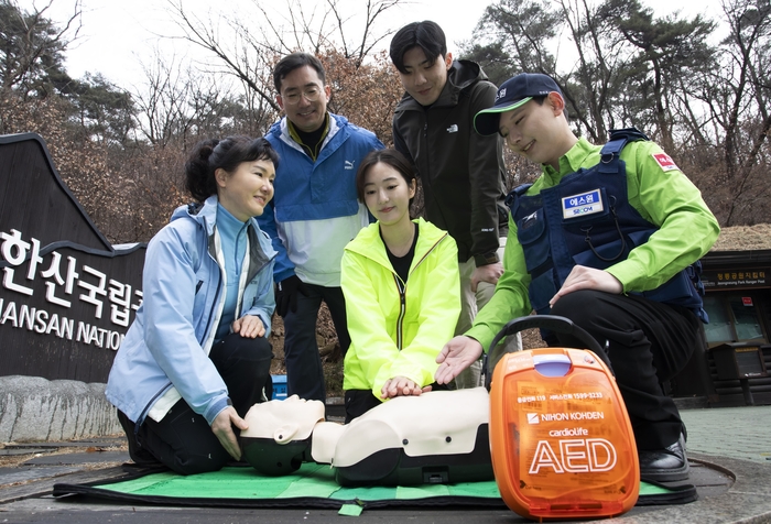 에스원 임직원이 공원 관계자에게 자동심장충격기(AED) 사용법을 안내하고 있다.(에스원 제공)