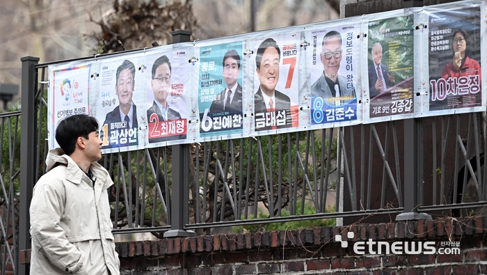 제22대 국회의원 선거 공식 선거운동 시작일인 28일 서울 종로구 마로니에공원 인근에서 한 시민이 종로구 국회의원 후보자들의 선거벽보를 살펴보고 있다. 이동근기자 foto@etnews.com