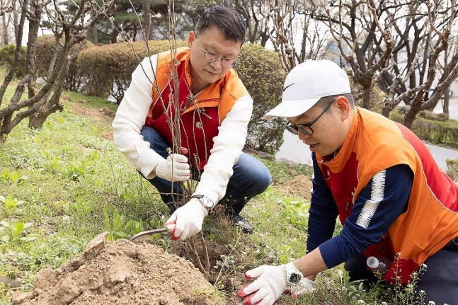 이호정 SK네트웍스 대표(왼쪽)가 식목일을 맞아 남산공원에서 무궁화 묘목 식재활동을 하고 있다.